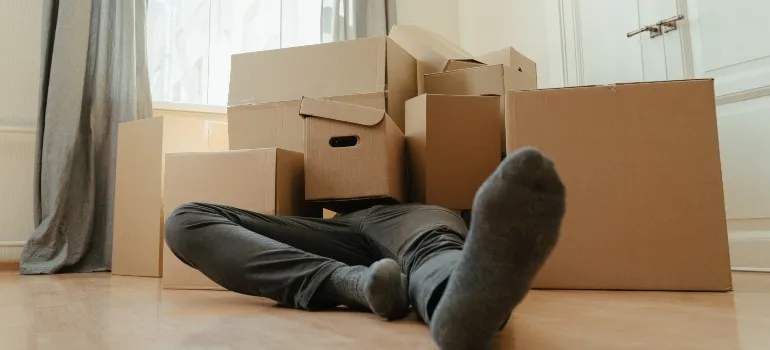Man covered with packing boxes