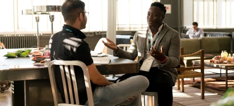 two men discussing something while sitting at the table