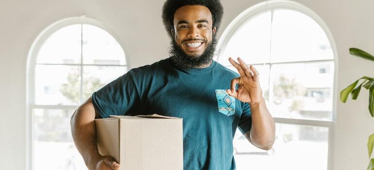 One of the movers Gaithersburg MD holding a moving box