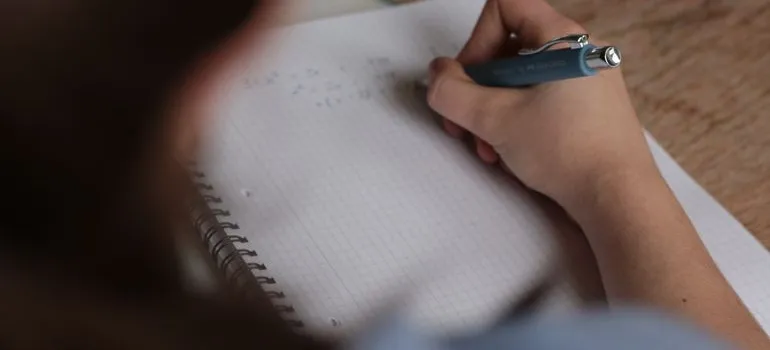 A person writing on the paper