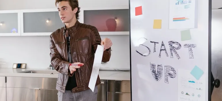 A man standing next to the board where is written startup