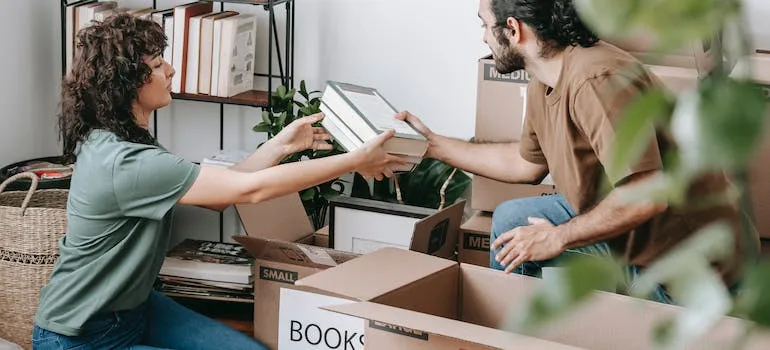 A couple packing books for moving