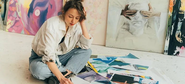 A person drawing and thinking about relocating fine art to Baltimore