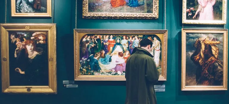 A person in front of the paintings thinking about relocating fine art to Baltimore