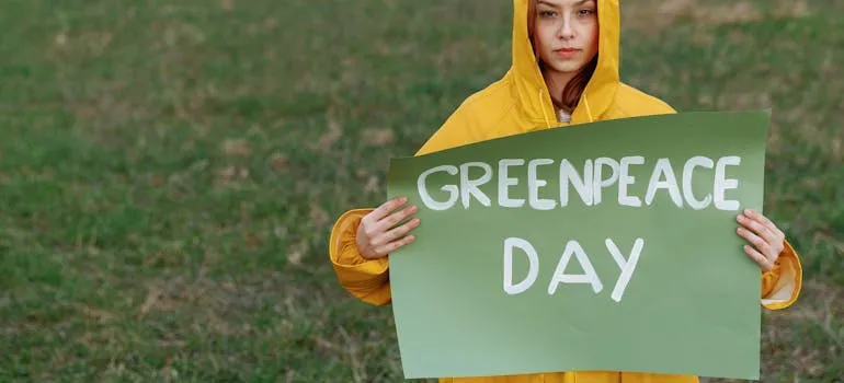 A person holding a Greenpeace day sign 