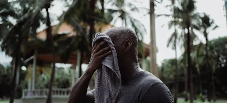 A man wiping his face with a towel 