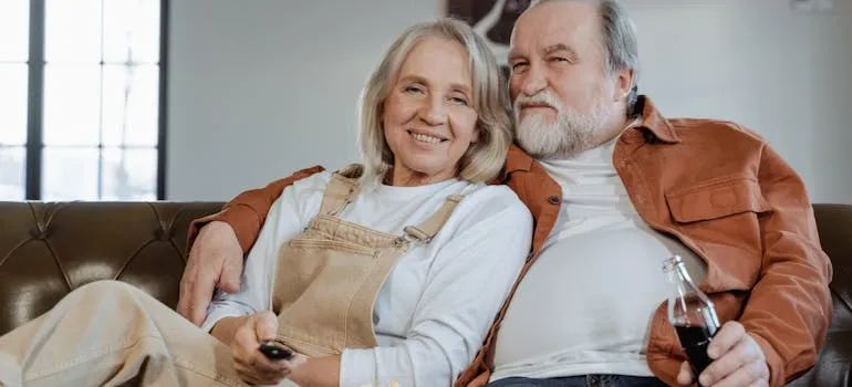 An elderly couple sitting on the couch