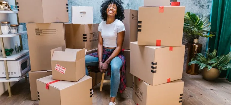 A woman sitting between moving boxes