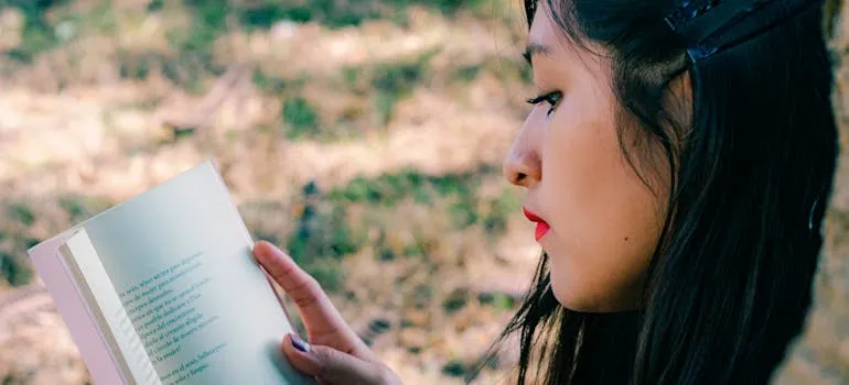 A woman reading a book in the park