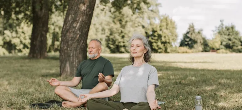 A couple doing yoga in the park
