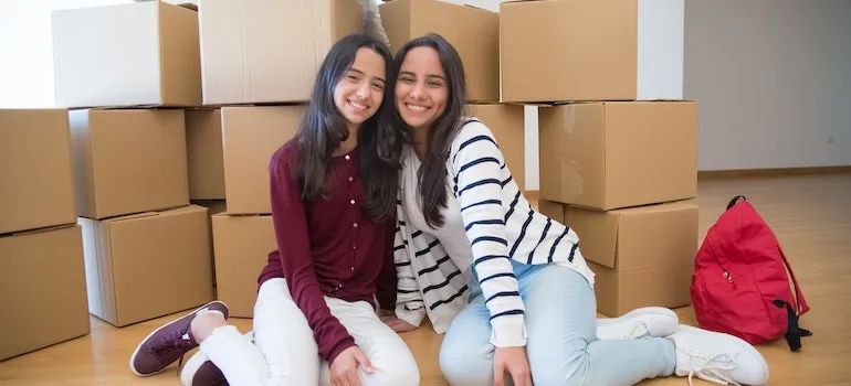 two content and happy girls after moving into a new home