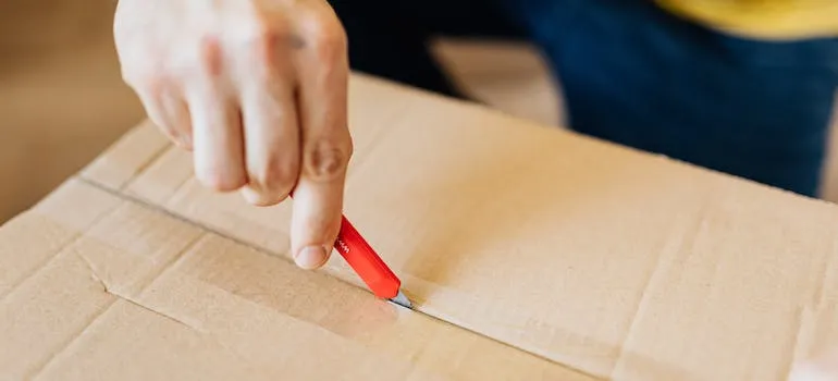 a person cutting a cardboard box