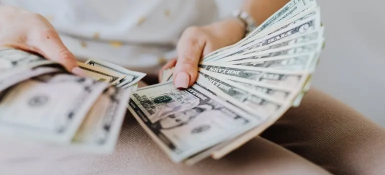A person calculating dollar bills