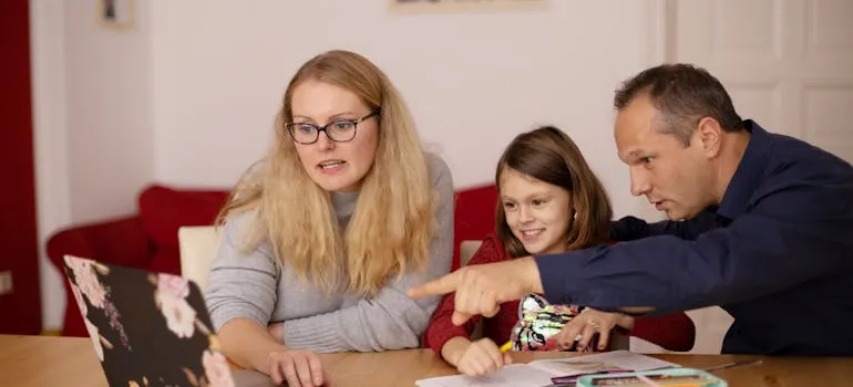Parents with the kid using a laptop