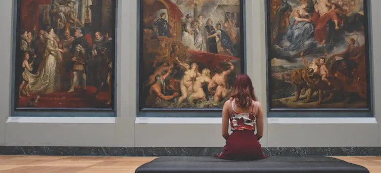 A woman sitting in front of the paintings