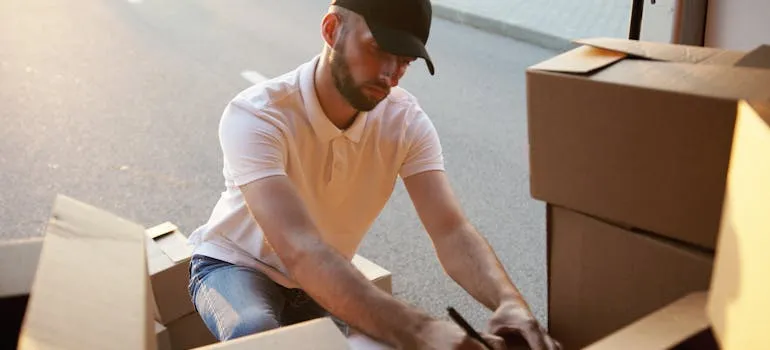 A mover taking an inventory of moving boxes