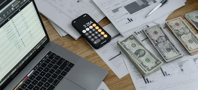 A dollar bills and a calculator on the table