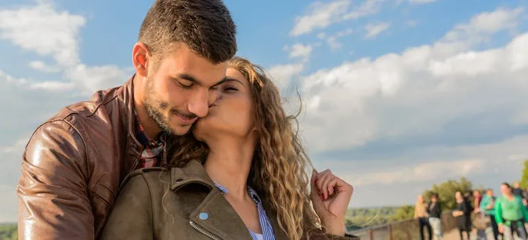 A woman kissing a man