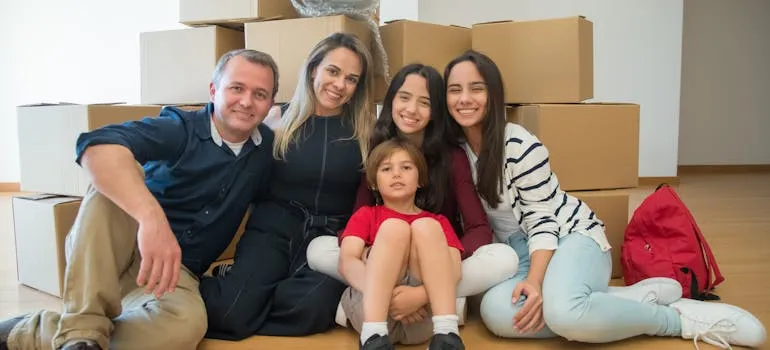 A family sitting in front of the moving boxes