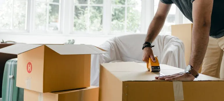 One of the movers North Potomac MD sealing a moving box