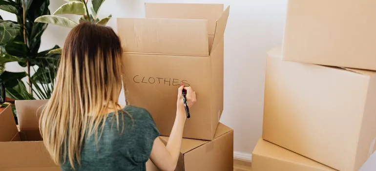A woman labeling a moving box for relocating from Rockville to Baltimore