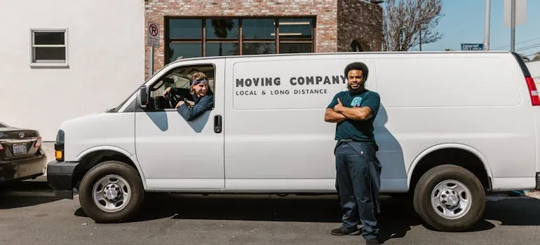 Two movers standing in front of the moving van 