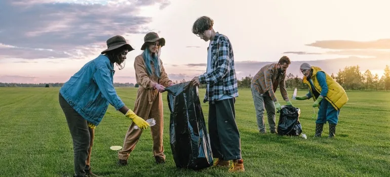 people collecting trash on the green grass