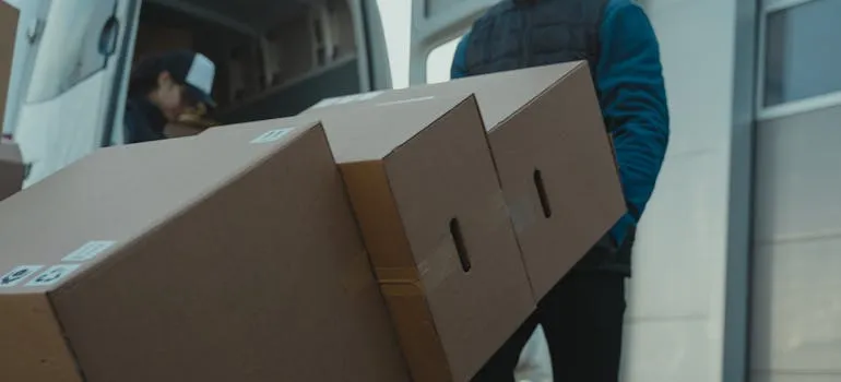 A mover loading moving boxes into the moving van