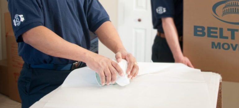 two residential movers Maryland packing a client's belongings