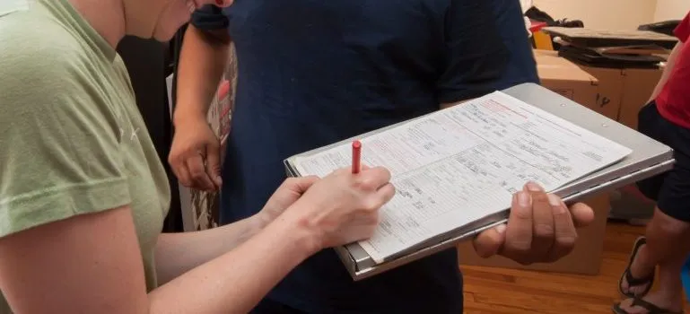 a client signing a contract after hiring Beltway Movers for their storage services