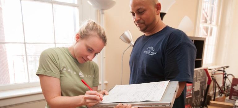 a woman signing documents with a Beltway Movers DMV professional