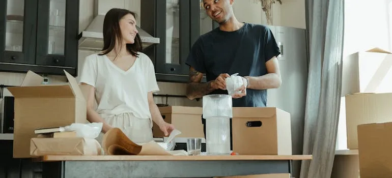 A couple packing by following room-by-room packing checklist