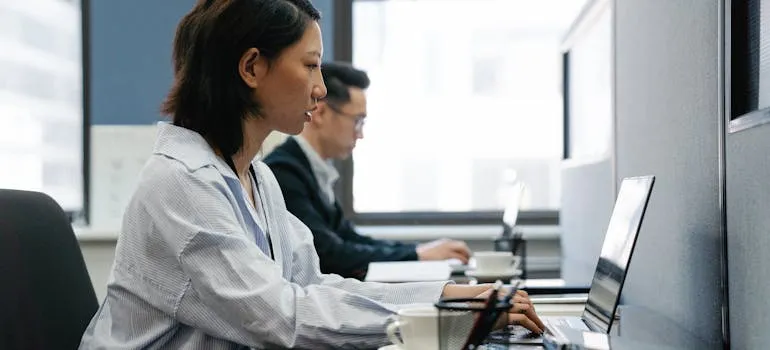 Two people using laptop