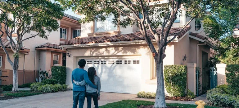 A couple in front of the house talking about the reasons to move to Bethesda