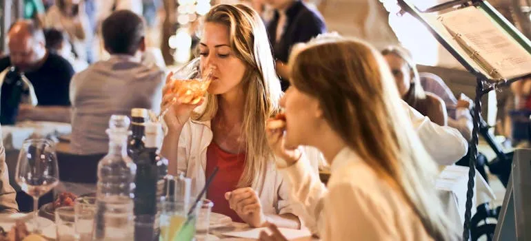 Two women in the restaurant talking about the reasons to move to Bethesda