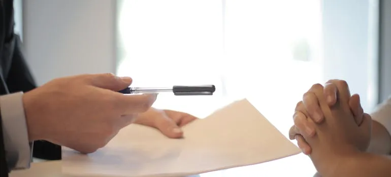 A person holding a pen and a paper