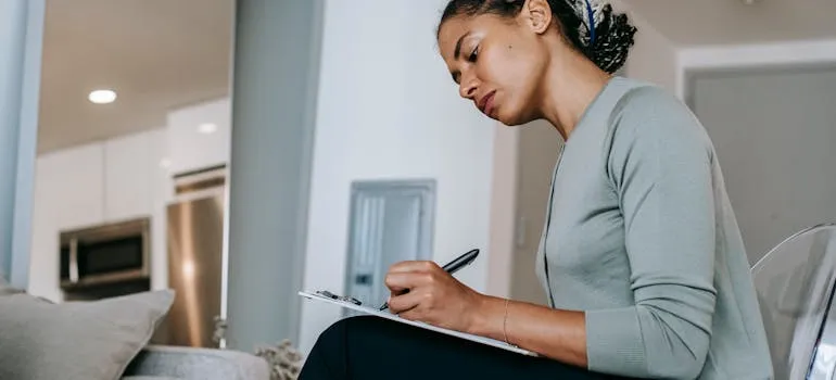 A woman writing a plan for relocating from Baltimore to Arlington