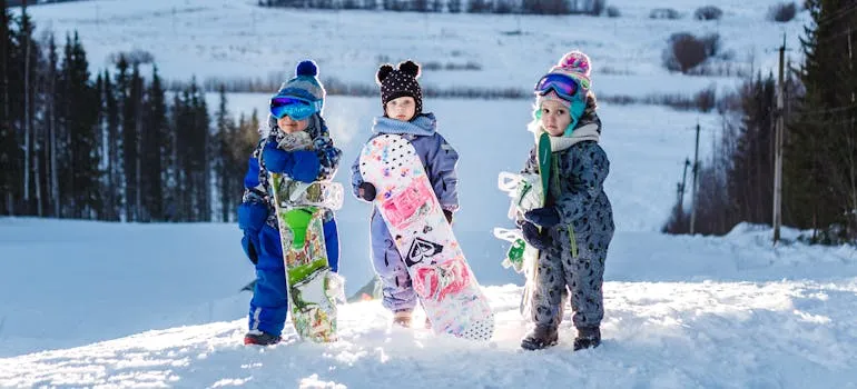 Kids holding snowboards