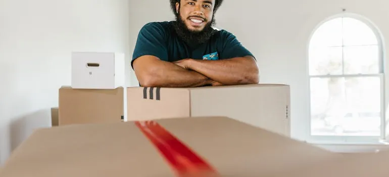 A mover standing next to the moving box