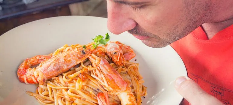 A man holding a plate with the seafood