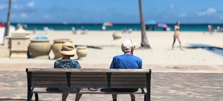 Two seniors on the bench talking about why Washingtonians are moving to Florida