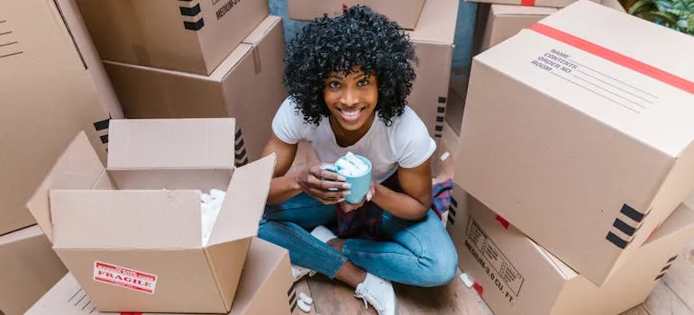 A woman sitting between moving boxes