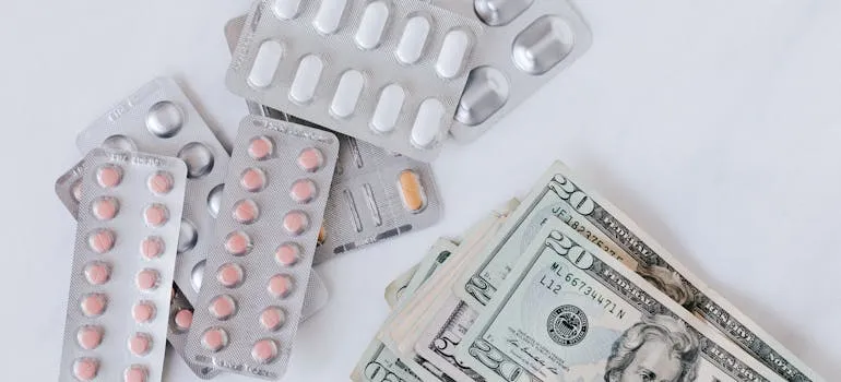 Dollar bills next to the pills