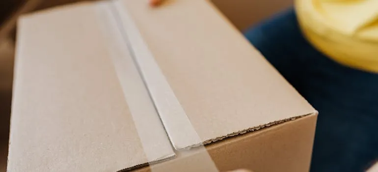 A person packing a moving box