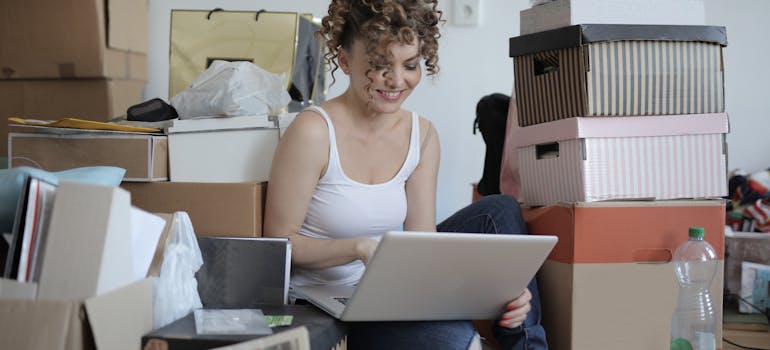 A woman using laptop to find how long does it take to pack an entire house