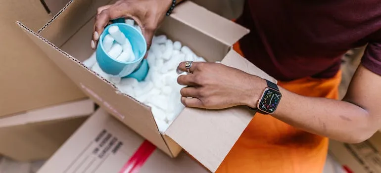 A person filling box with packing peanuts 