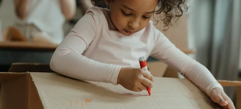 A kid writing on the box