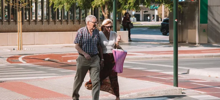 A senior couple crossing street