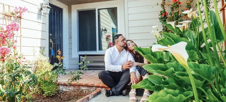 A couple sitting in front of the house