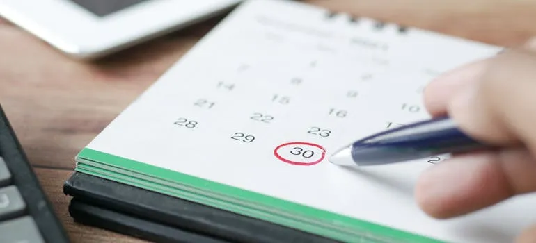 A person holding a pen and a calendar 